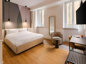 a hotel room with a bed and a desk at Numa Rome Condotti in Rome