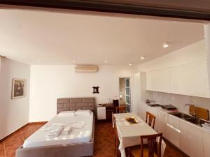 a bedroom with a bed and a table and a kitchen at Vila Rexhepaj in Vlorë