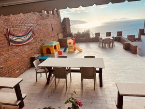 a patio with a table and chairs and a playground at Vila Rexhepaj in Vlorë
