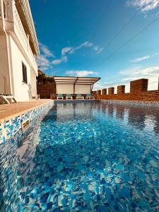 a swimming pool with blue water in front of a building at Vila Rexhepaj in Vlorë +46 photos