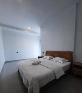 a bedroom with a large bed in a white room at Poshaka Karimunjawa in Karimunjawa +2 photos