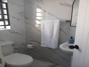 a white bathroom with a toilet and a sink at Ficus self catering in Burgersfort +13 photos