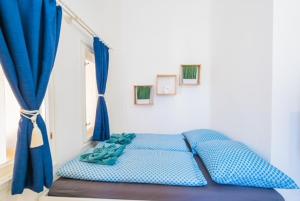 a bedroom with a blue bed with blue curtains at Corso Apartman in Siófok