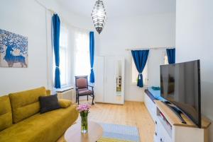 a living room with a couch and a tv at Corso Apartman in Siófok