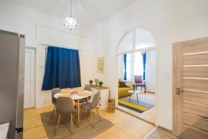 a dining room and living room with a table and chairs at Corso Apartman in Siófok