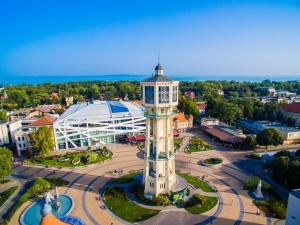 a building with a tower in the middle of a city at Corso Apartman in Siófok