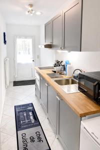 a white kitchen with a sink and a microwave at Haus Sternenstrand Tossens in Tossens +32 photos