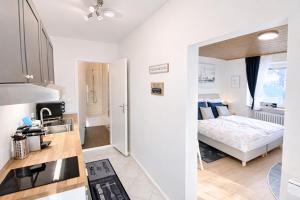 a kitchen and a bedroom with a bed in a room at Haus Sternenstrand Tossens in Tossens