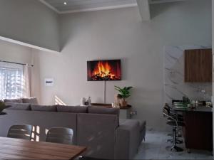 a living room with a couch and a fire on the wall at Ficus self catering in Burgersfort