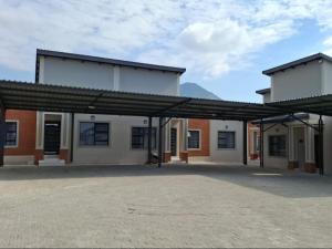 a large building with awning in a parking lot at Ficus self catering in Burgersfort