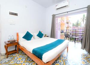 a bedroom with a large bed and a balcony at Joystays Renton Manor in Arpora +18 photos