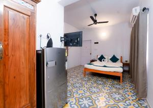 a living room with a refrigerator and a couch at Joystays Renton Manor in Arpora