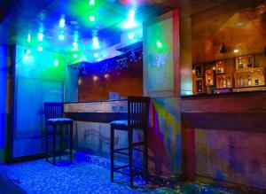 a bar with two chairs in a room with lights at Joystays Renton Manor in Arpora