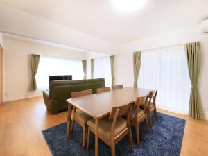 a dining room with a table and chairs and a couch at Knowledge House in Odawara