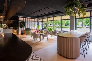 a restaurant with tables and chairs and windows at TULIP Hotels & Residences - Zwolle in Zwolle