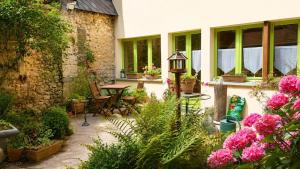 a garden with a table and chairs and flowers at La Maisonnette in Les Andelys