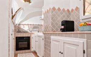 a kitchen with white cabinets and a sink at Amazing Two-Bedroom House with Sea View in Cala di Volpe in Porto Cervo