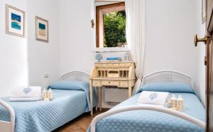 two blue beds in a room with a desk at Amazing Two-Bedroom House with Sea View in Cala di Volpe in Porto Cervo