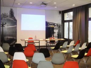 a conference room with chairs and a projection screen at ibis Montargis in Montargis