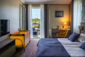a hotel room with a bed and a television at Korona Hotel in Ostrołęka +68 photos