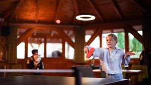 a young boy is holding a ping pong ball at Hotel MY Kramerwirt in Geiersthal +129 photos