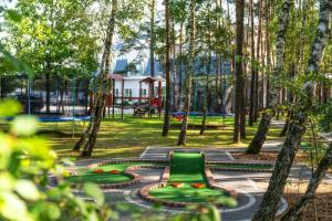 a park with a green bench and a garden at Korona Hotel in Ostrołęka