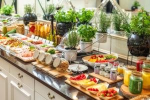 a buffet with many plates of food on a counter at Korona Hotel in Ostrołęka