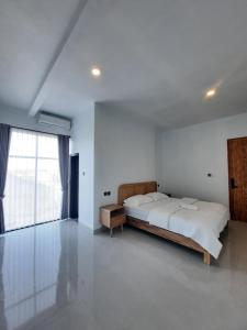 a bedroom with a large bed and a large window at Poshaka Karimunjawa in Karimunjawa