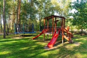 a playground with two slides and a play structure at Korona Hotel in Ostrołęka