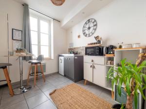a kitchen with a clock on the wall at Le Pont Ravet in Bernay