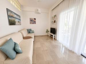 a living room with a couch and a tv at Apartment Dolphin Sea View and First Line in Hanioti