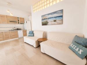 a living room with a white couch and a kitchen at Apartment Dolphin Sea View and First Line in Hanioti