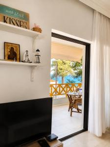 a living room with a door leading to a patio at Apartment Dolphin Sea View and First Line in Hanioti +28 photos
