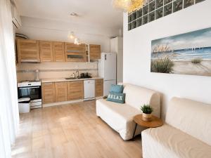 a living room with a couch and a kitchen at Apartment Dolphin Sea View and First Line in Hanioti