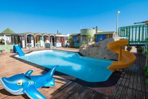 a pool with a slide and a dolphin playground at B&B Residence Sorriso in Cattolica