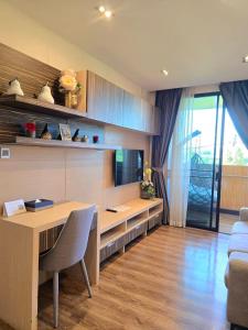 a room with a desk with a television and a couch at Blue Sky Private Pool Villa in Chiang Mai