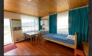 a bedroom with a bed and a table and windows at Terelj Khangai Resort in Belen Hüryee Hiid