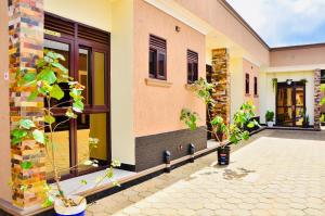 a house with two potted plants in front of it at Townside Suites in Kyebando