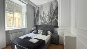 a bedroom with a bed and a painting on the wall at P&J Apartments Floriańska in Krakow