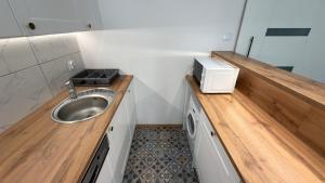 a small bathroom with a sink and a microwave at P&J Apartments Floriańska in Krakow +248 photos