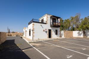 a building with a balcony in a parking lot at Home2Book La Molina A, Cozy Terrace Retreat in Triquivijate