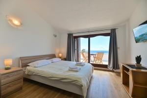 a bedroom with a bed with a view of the ocean at LUXURY VILLA CIOVO Sleeps 17, Infinity Pool, Seafront in Trogir +44 photos