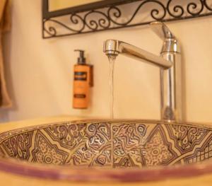 a bathroom sink with water coming from a faucet at Merzouga Luxury Tents & Activities in Merzouga +47 photos