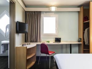 a room with a bed and a desk and a window at ibis Thonon Centre in Thonon-les-Bains