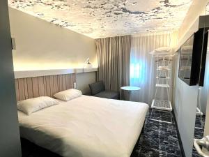 a bedroom with a white bed and a room with a ladder at ibis Clermont Ferrand Montferrand in Clermont-Ferrand