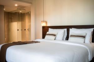 a bedroom with a large bed with white sheets and pillows at ananea Hurghada - Adults Only in Hurghada