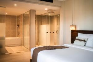 a bedroom with a bed and a shower and a tub at ananea Hurghada - Adults Only in Hurghada