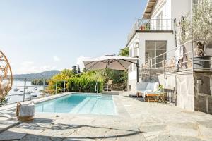 a villa with a swimming pool with a view of the water at Lake House Lesa - Lakeside Villa Lago Maggiore in Lesa