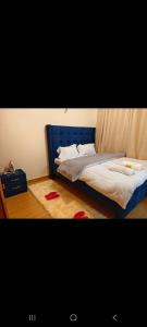 a bed in a room with a blue head board at Shekhy Homes in Machakos