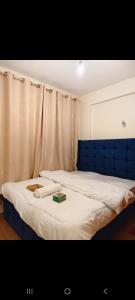 a bedroom with a bed with a blue head board at Shekhy Homes in Machakos